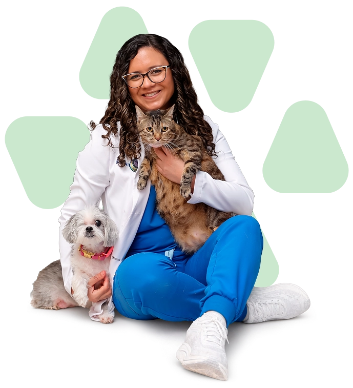 Dra. Sheila sentada con un perro y gato